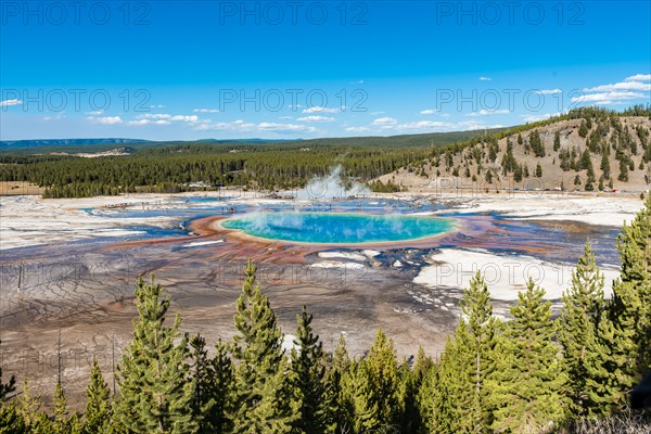 Visitors on footbridge over steaming hot spring with coloured mineral deposits