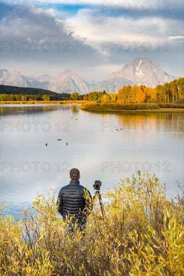 Photographer standing with tripod at the river