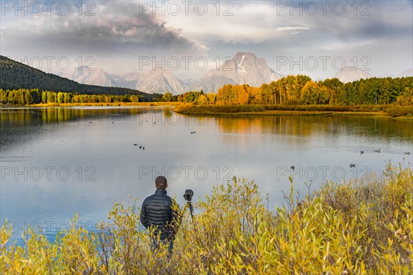 Photographer standing with tripod at the river