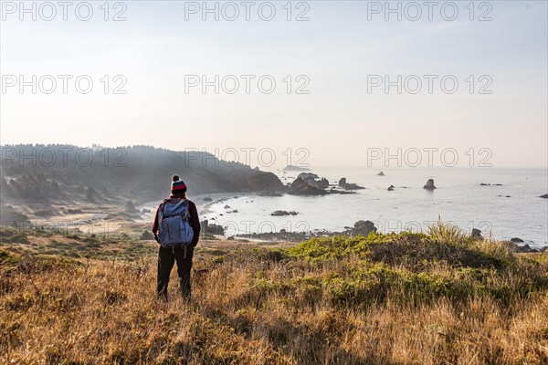 Female hiker looking out for coastal scenery with many rugged rocky islands