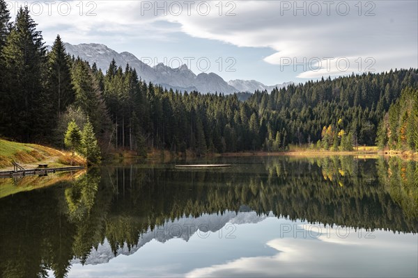 Mountains and forest are reflected in the calm lake