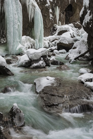 Wild river Partnach in the Partnachklamm with long icicles and snow in winter