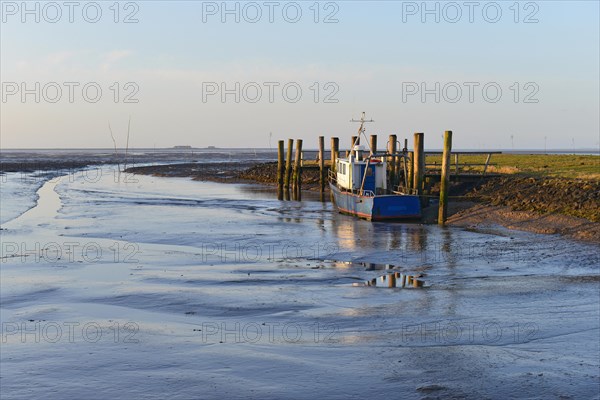 Fishing boat in a small harbor at low tide