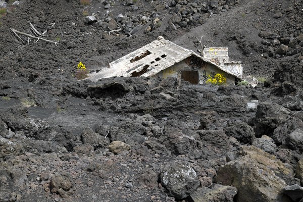 House covered with lava on the slopes of Mount Etna