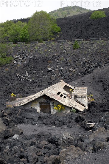 House covered with lava on the slopes of Mount Etna