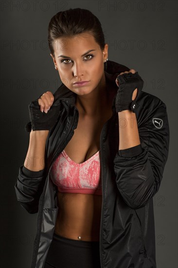 Portrait of a young woman with dark hair tied together in a sporty outfit