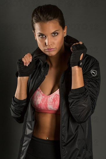 Portrait of a young woman with dark hair tied together in a sporty outfit