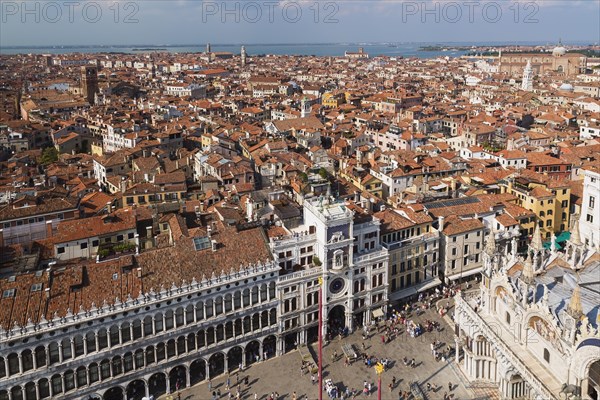Procuratie Vecchie building with St Mark's clock tower and St Mark's Basilica and old architectural style residential buildings with terracotta rooftops taken from the Campanile bell tower in St Mark's Square