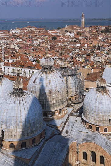 St Mark's Basilica with Romanesque domes and ornate Gothic and Byzantine architectural details plus old Renaissance architectural style residential buildings with terracotta rooftops and lagoon