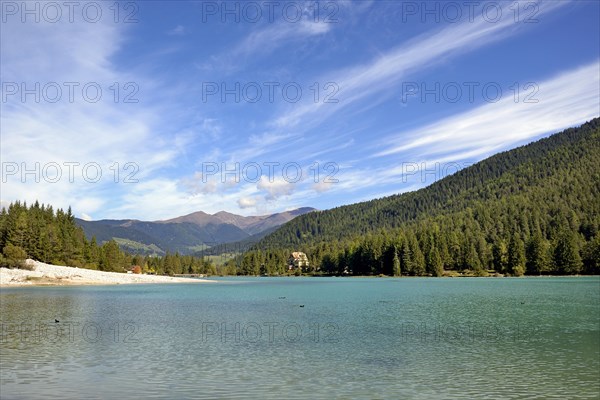 View over the emerald green lake Dobbiaco with mountain forest and Murengang