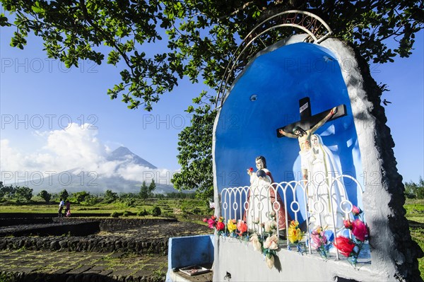 Christian statue before volcano Mayon