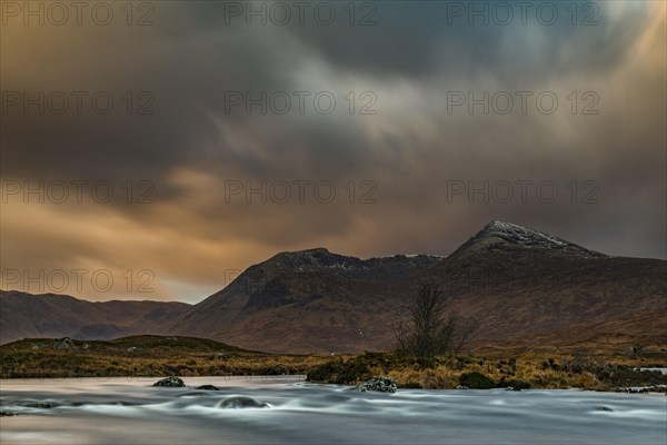 River Ba with mountain peaks of Meall aÂ´Bhuiridh and Clach Leathad in the background and dramatic clouds