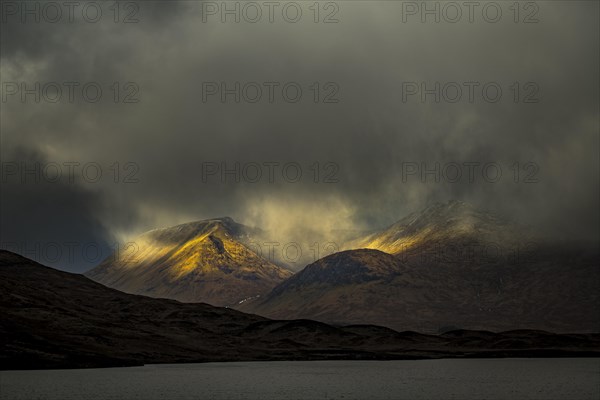 River Ba with mountain peaks of Meall aÂ´Bhuiridh and Clach Leathad in the background and dramatic clouds