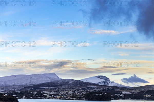 Portree in winter at sunrise with Old man of Storr and Bergen in the background