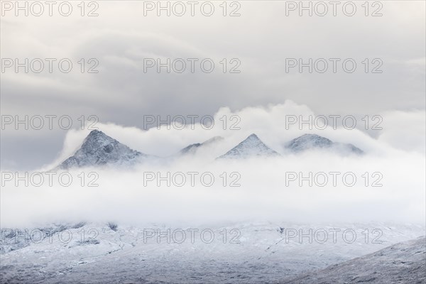 Snow-covered mountain peaks of the Cullins Group with clouds in snow-covered landscape