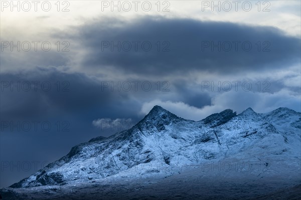 Snow-covered mountain peaks of the Cullins Group with clouds in snow-covered landscape