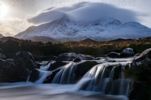 Waterfall of AltDearg Mor with snow-covered peaks of Marsco and Sgurr Nan Gillean