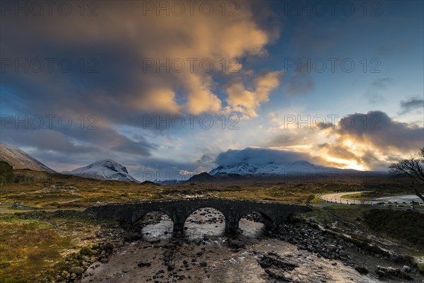 Sligachan Bridge with snow-covered peaks of Marsco and Sgurr Nan Gillean at sunset