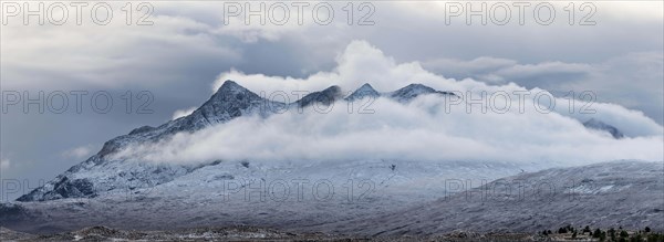 Snow-covered mountain peaks of the Cullins Group with clouds in snow-covered landscape