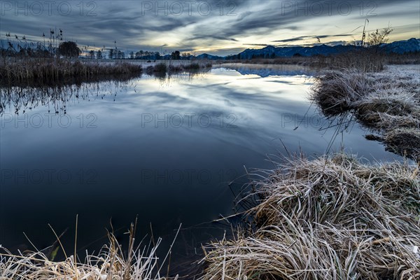 Water surface of the Ach with reflection and dramatic sky