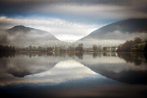 Hilly landscape with trees reflected in water surface