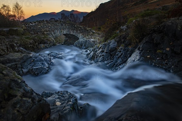 Old stone bridge with mountain stream