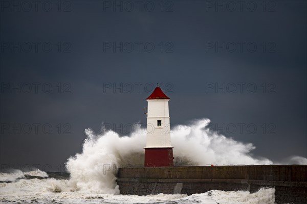 Berwick Lighthouse with strong surf and dark cloudy sky