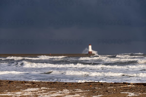 Berwick Lighthouse with strong surf and dark cloudy sky