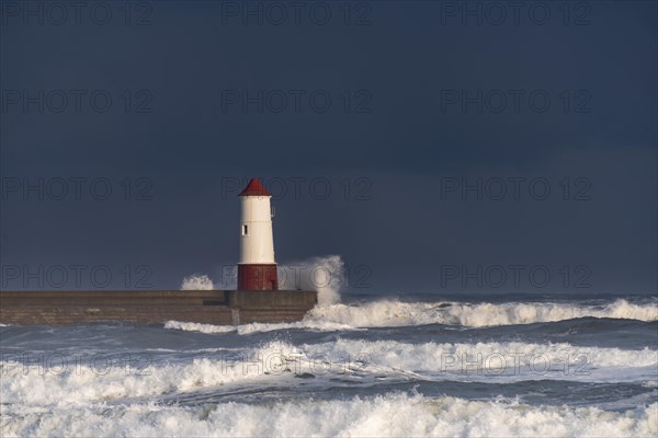 Berwick Lighthouse with strong surf and dark cloudy sky