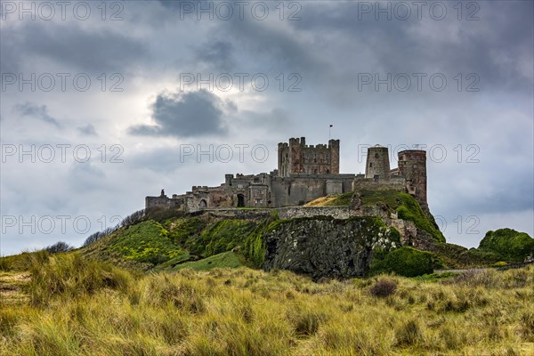 Dune landscape with Bamburgh Castle under a cloudy sky