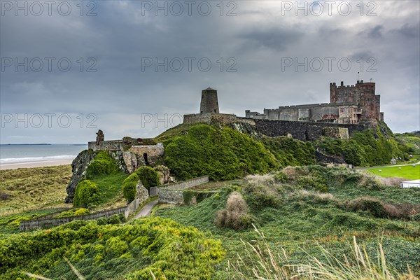 Dune landscape with Bamburgh Castle under a cloudy sky