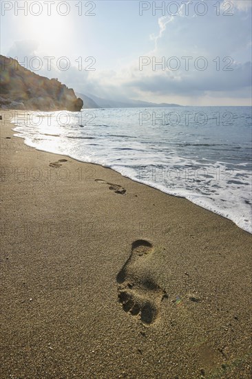 Footsteps in the wet sand at shore