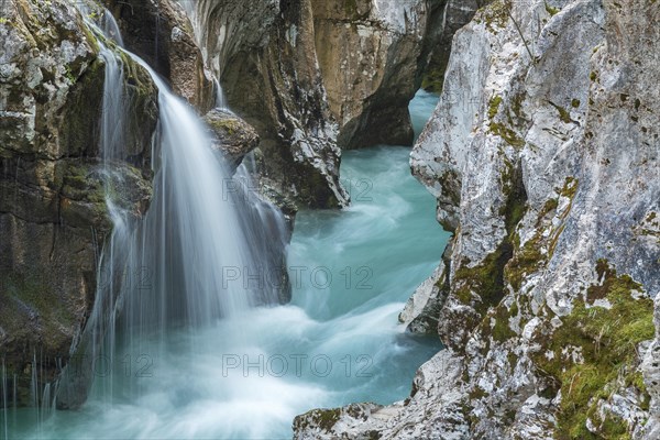 Emerald green wild river Soca flows through narrow canyon