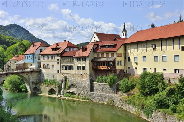 City view Skofja Loka with buildings from the 14th century and the Capuchin bridge over the river Sora