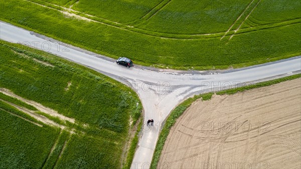 Rural intersection with parked car and two persons