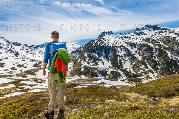 Young man hiker looks into the distance