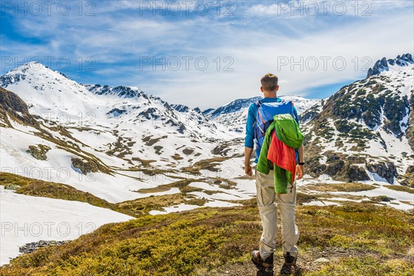 Young man hiker looks into the distance