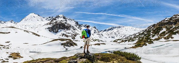 Hiker stands in front of mountain landscape