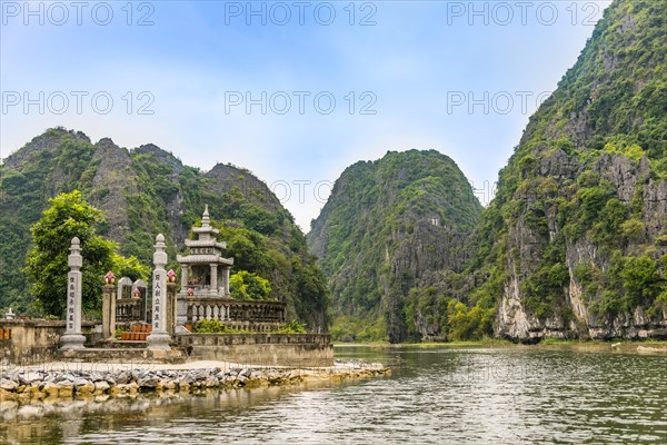 Small temple with forested limestone rocks