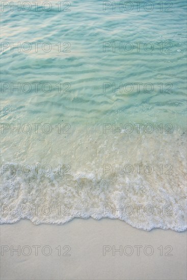 Waves on sandy beach with turquoise water at Koh Tui Beach