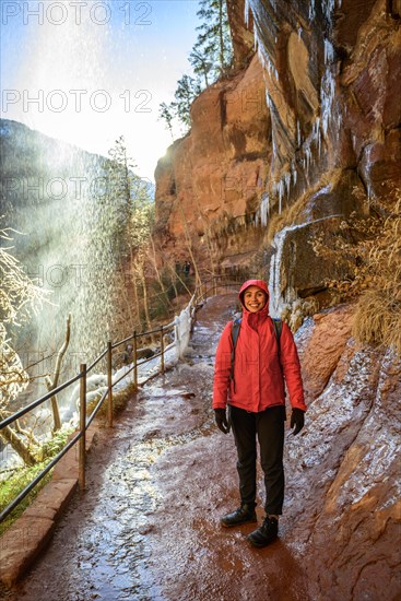 Female hiker in front of waterfall