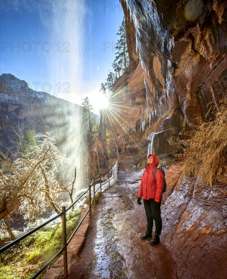 Female hiker in front of waterfall