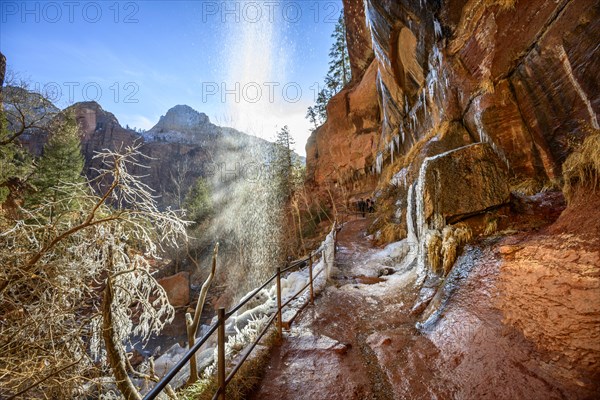 Waterfall falls from overhanging rock in winter