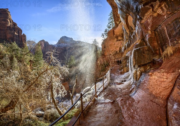 Waterfall falls from overhanging rock in winter