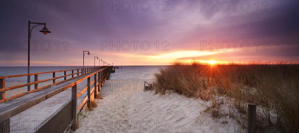 Pier on the beach at sunrise