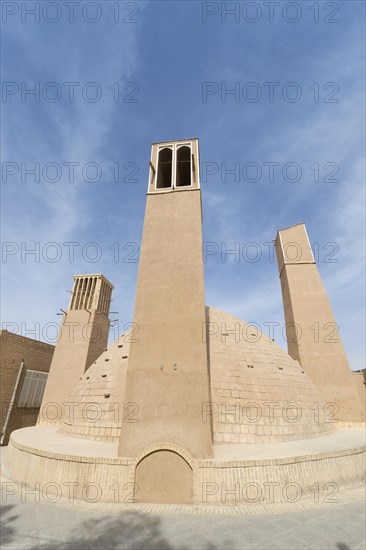 Old water reservoir surrounded by three windtowers