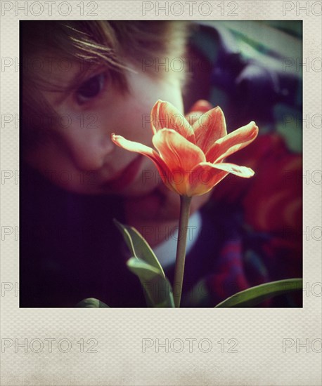 Little girl looking at a flower