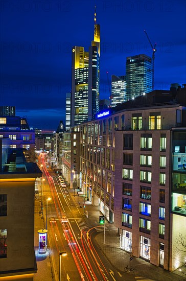 View of the illuminated Borsenstrasse with car traffic and skyline with Comerzbank Tower