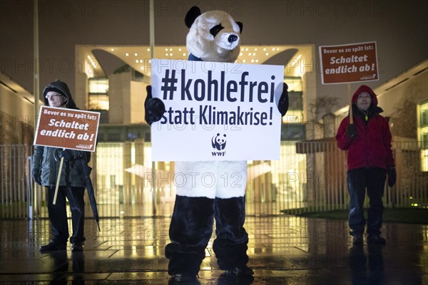 Demonstrator disguised as a panda bear with sign Coal-free instead of climate crisis in protests for a quick exit from coal energy and for compliance with climate protection goals in front of the Federal Chancellery