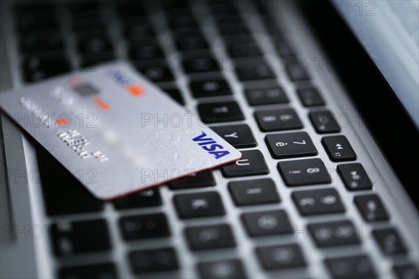 Visa credit card on a keyboard of a computer